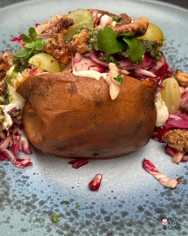 Nahaufnahme desselben Gerichts von oben: die Füllung aus Walnüssen, Trauben, Radicchio und Granatapfelkernen auf dem hellblauen Teller.